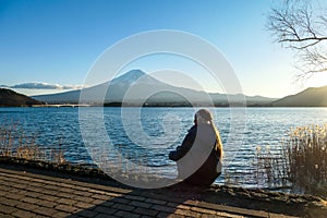 Japan - A woman sitting at the Kawaguchiko Lake side and watching Mt Fuji