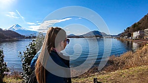 Japan - A woman standing at the side of Kawaguchiko Lake with the view on Mt Fuji