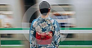 Japan woman, travel and train station in kimono and public transportation on metro bullet in city. Person, motion blur