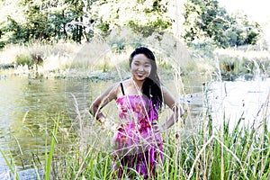 Japanese American Woman At River Smiling In Floral Dress