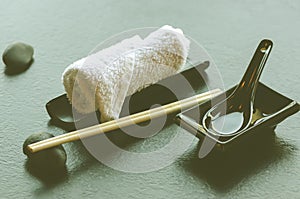 Japanese, asian food utensils - pair of chopsticks, hot weat towel, ceramic black spoon, dark stone in restaurant, cafe