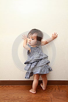 Japanese baby girl pulling up to standing