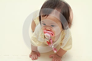 Japanese baby girl sucking on a pacifier