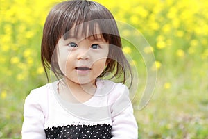 Japanese baby girl and yellow field mustard