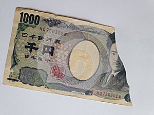 Japanese banknote of 1000 yen on the broken sheet of paper