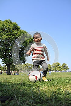 Japanese boy kicking a soccer ball