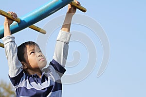 Japanese boy playing with a monkey bars