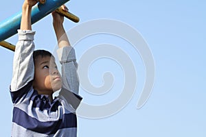 Japanese boy playing with a monkey bars