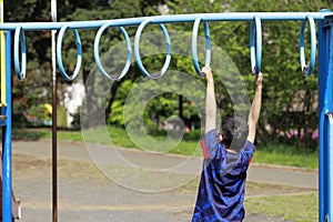 Japanese boy playing with a monkey bars