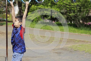 Japanese boy playing with a monkey bars