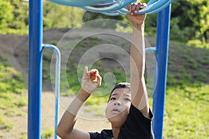 Japanese boy playing with a monkey bars