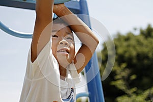 Japanese boy playing with a monkey bars