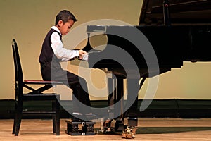 Japanese boy playing piano on stage