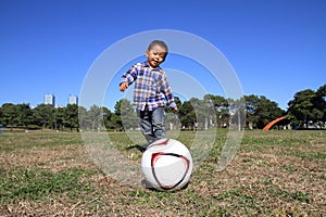 Japanese boy playing with soccer ball