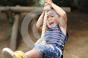 Japanese boy playing with tarzan rope