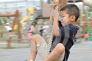 Japanese boy playing with Tarzan rope