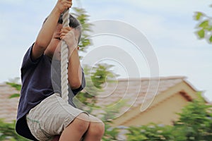 Japanese boy playing with Tarzan rope