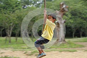 Japanese boy playing with Tarzan rope