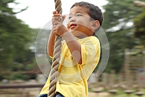 Japanese boy playing with Tarzan rope