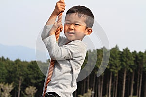 Japanese boy playing with Tarzan rope