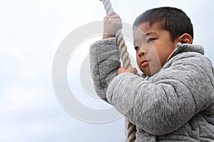 Japanese boy playing with Tarzan rope