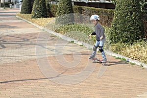 Japanese boy riding on a casterboard