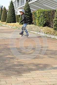 Japanese boy riding on a casterboard