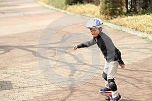 Japanese boy riding on a casterboard