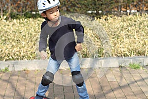 Japanese boy riding on a casterboard