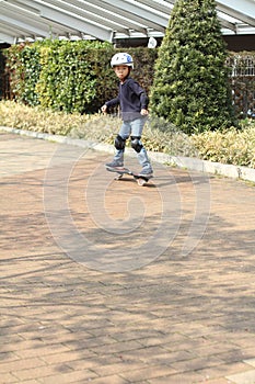 Japanese boy riding on a casterboard