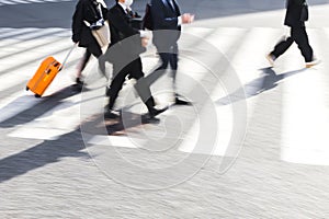 Japanese business men crossing a city street on a zebra crossing