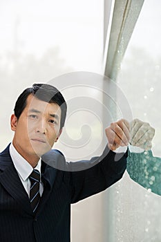 Japanese businessman leaning on a window