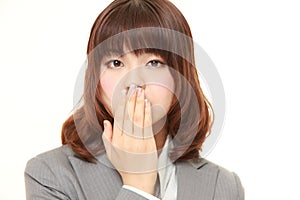 Japanese businesswoman making the speak no evil gesture