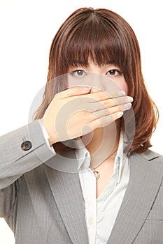 Japanese businesswoman making the speak no evil gesture