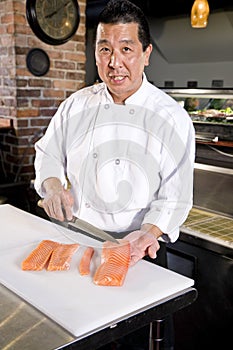 Japanese chef slicing raw fish for sushi photo