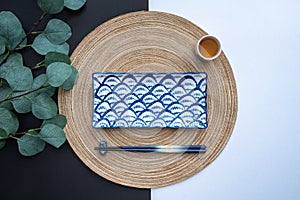 Japanese or Chinese table setting with traditional table mat and dinnerware with back and white background.