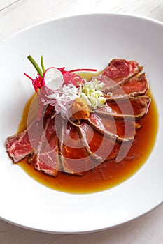 Japanese cuisine beef tataki poured with soy sauce