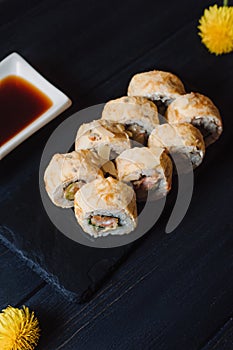 Japanese cuisine. Japanese sushi with soy sauce and wasabi on black stone plate on black background