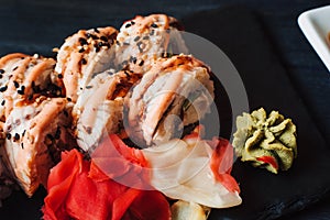 Japanese cuisine. Japanese sushi with soy sauce and wasabi on black stone plate on black background