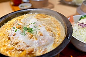 Japanese cuisine, Katsu Toji or fried Breaded Pork Tenderloin with Steamed Eggs served in hot bowl