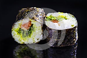 Japanese Cuisine. Macro Shoot of Two Traditional Sushi Rolls With Salmon and Laminaria Together on Black Surface