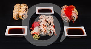 Japanese cuisine. Set of sushi with ginger on black stone plate on black background. Top view