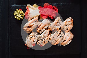 Japanese cuisine. Sushi with ginger on black stone plate on black background. Top view