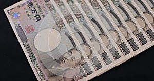 Japanese currency 100,000 yen on the black background panning
