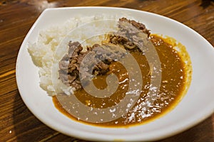 Japanese curry with rice topped with beef and onion simmered in a mildly sweet sauce flavored