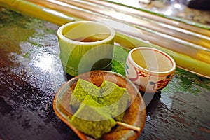 Japanese desert and tea on the table near the bamboo track