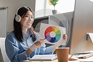 Japanese Designer Woman Showing Color Palette To Computer In Office