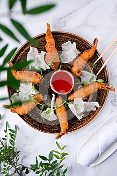 Japanese dish , battered deep fried seafood Tiger Prawns . Served with sauce