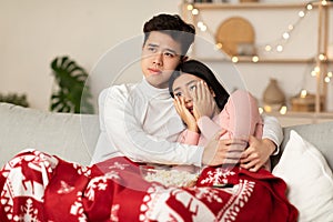 Japanese Family Couple Watching Scary Movie On TV At Home