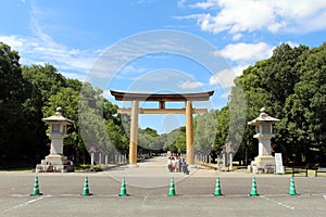 Japanese family taking photo in front of Entrance torii gate of Kashihara Jingu Temple